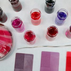 LearnOnline Self-study IGCSE Chemistry - birds eye view of laboratory dishes with liquids and powders all in tones of pink
