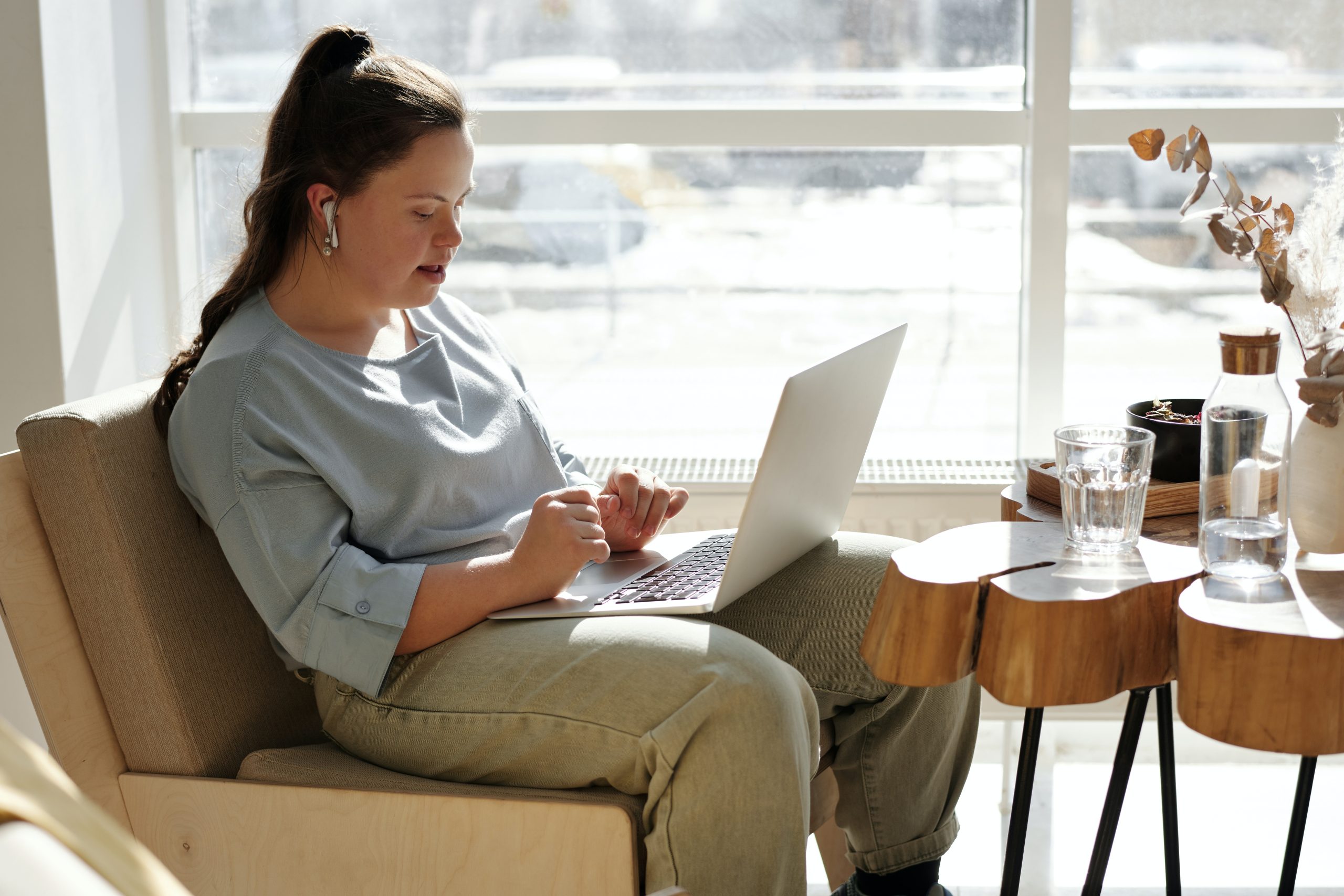 Why LearnOnline? Girl studying with headphones in and laptop on lap