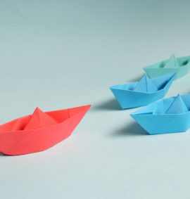 LearnOnline Leadership in Any Role Business Training Courses Four green and blue paper boats following a larger red paper boat