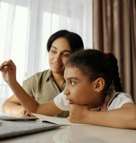 LearnOnline Science IGCSE Package. Mother and daughter reading something on computer
