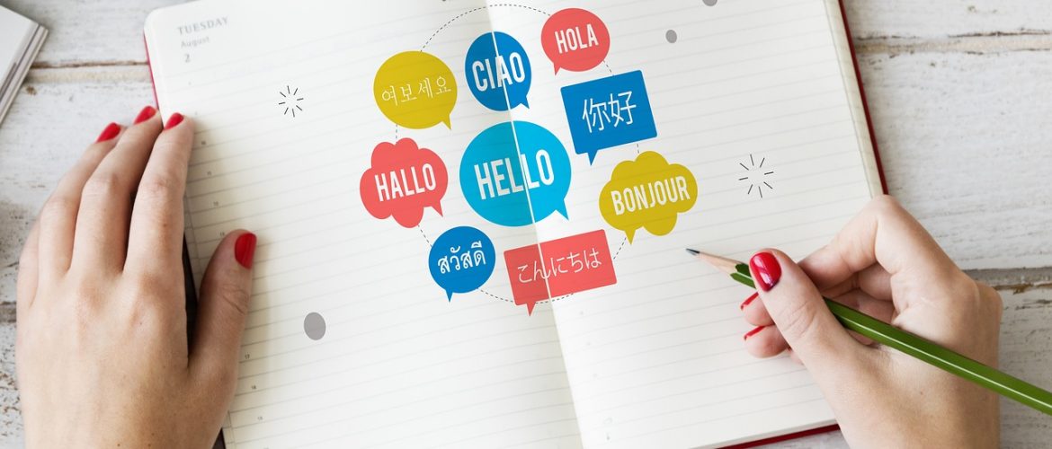 Open notebook with different languages written in speech bubbles