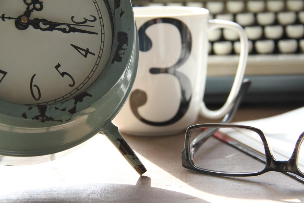 Image of clock, mug, glasses and typewriter