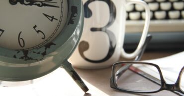 Image of clock, mug, glasses and typewriter