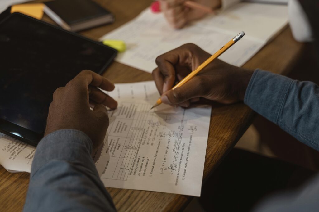 image of hands marking work on a desk