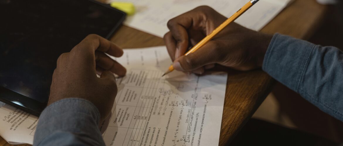 image of hands marking work on a desk