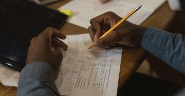 image of hands marking work on a desk