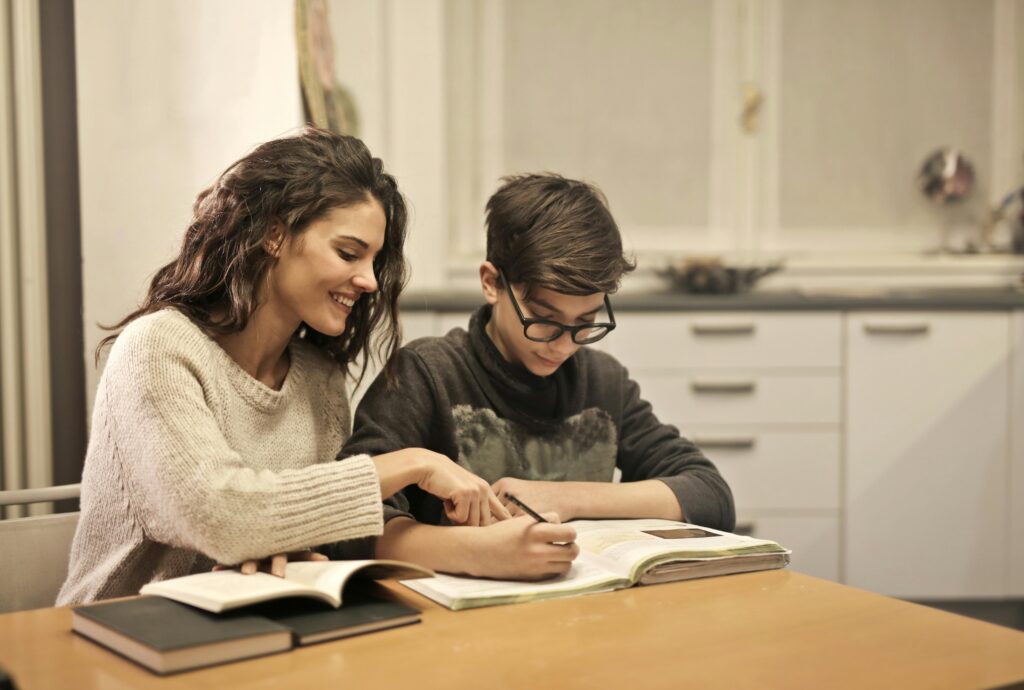 Parent and child reading book at table