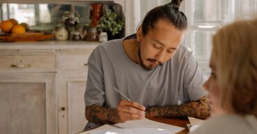 Adult studying at a table in kitchen